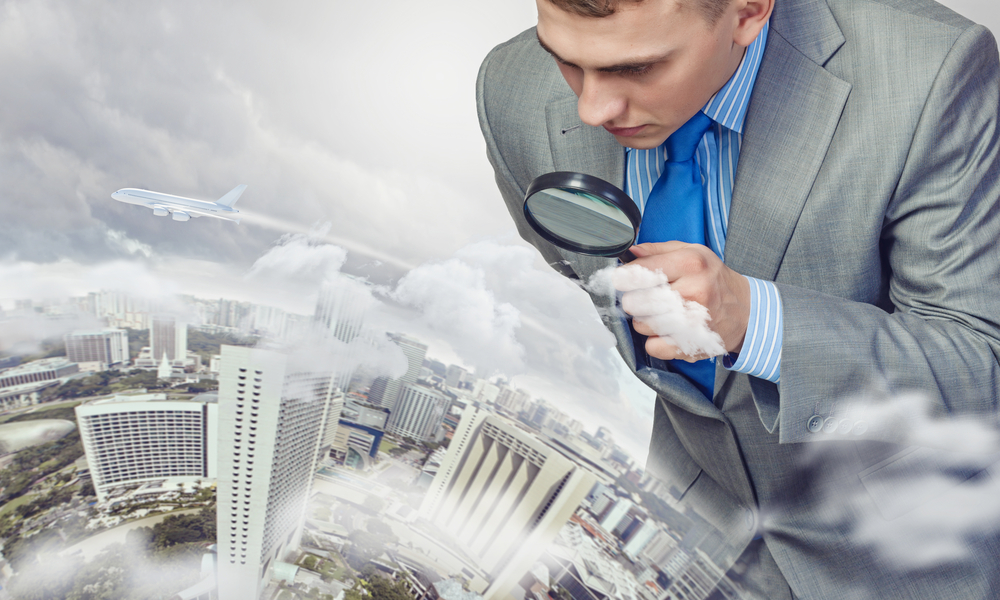 Image of businessman examining objects with magnifier